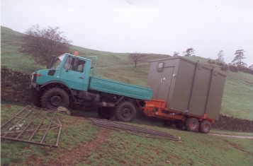Unimog U1300L towing another cell phone equipment cabin